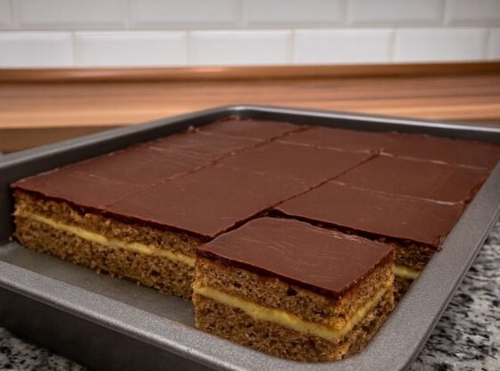 Sastojci za kremu: 3 dl mlijeka 20 dag šećera 4 žlice brašna 1 žumanjak 20 dag maslaca Priprema kreme: U loncu zakuhaj mlijeko, šećer, brašno i žumanjak te kuhaj na pari uz stalno miješanje dok se ne zgusne. Kad se krema malo ohladi, umiješaj maslac i miješaj dok ne postane glatka i sjajna. Ohlađeni biskvit prereži po dužini na pola. Premaži donju polovicu s dvije trećine kreme, pokrij drugim dijelom biskvita i premaži preostalom trećinom kreme po vrhu. Glazura od čokolade: 5 dag margarina 10 dag čokolade za kuhanje Po želji: malo mlijeka i šećera Priprema glazure: Na laganoj vatri otopi margarin i čokoladu. Po želji dodaj malo šećera i mlijeka za mekšu strukturu. Prelij kolač glazurom i poravnaj površinu. Ohladi Ružine kocke u hladnjaku nekoliko sati da se svi slojevi sjedine i stvrdnu. Reži na kocke i uživaj u ovom neodoljivom spoju kave, kreme i čokolade! Savjeti: Za još bogatiji okus možeš dodati par kapi ruma u biskvit. Kolač je još bolji drugi dan kad se sve arome prožmu.